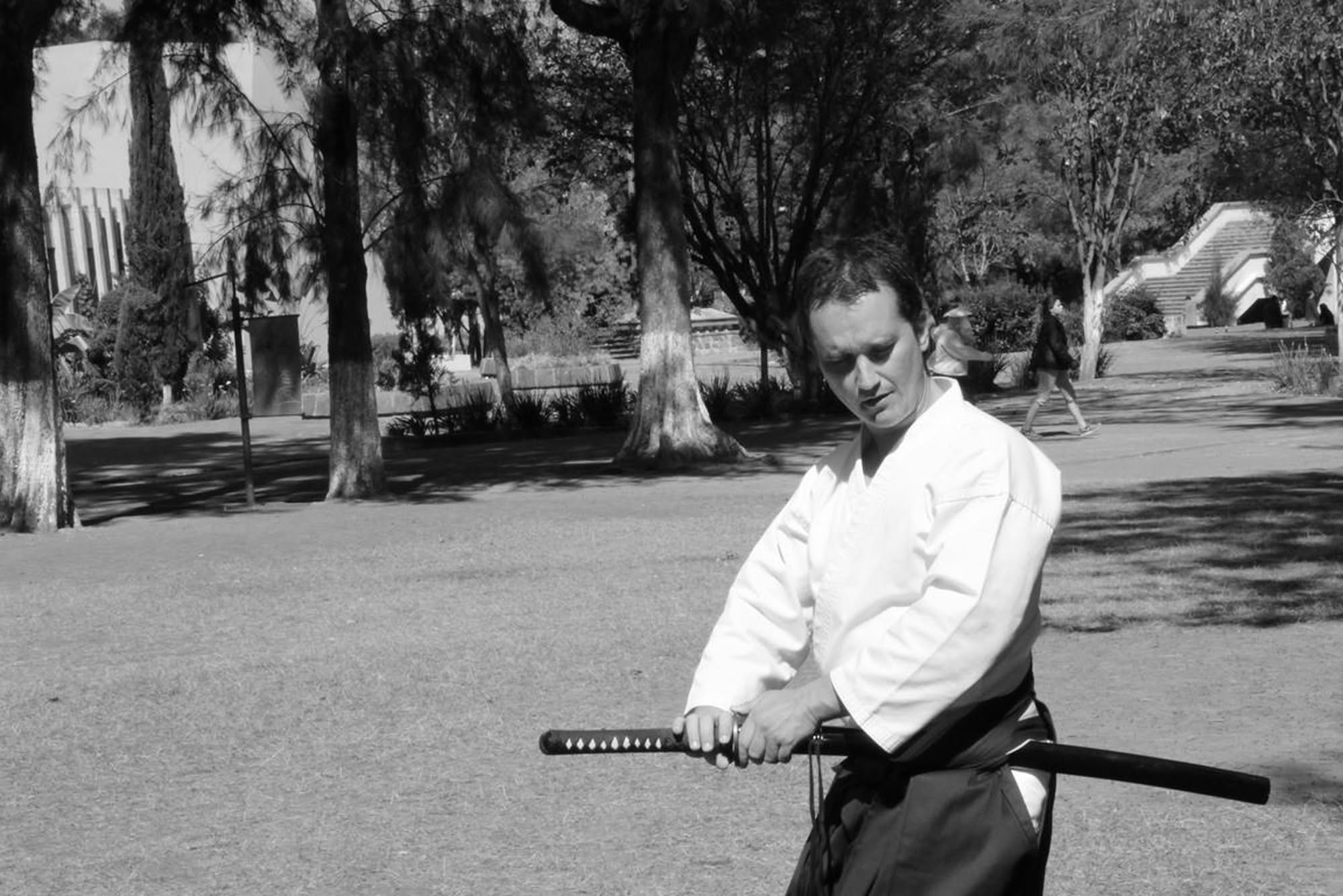 Fotografía en blanco y negro de práctica con katana